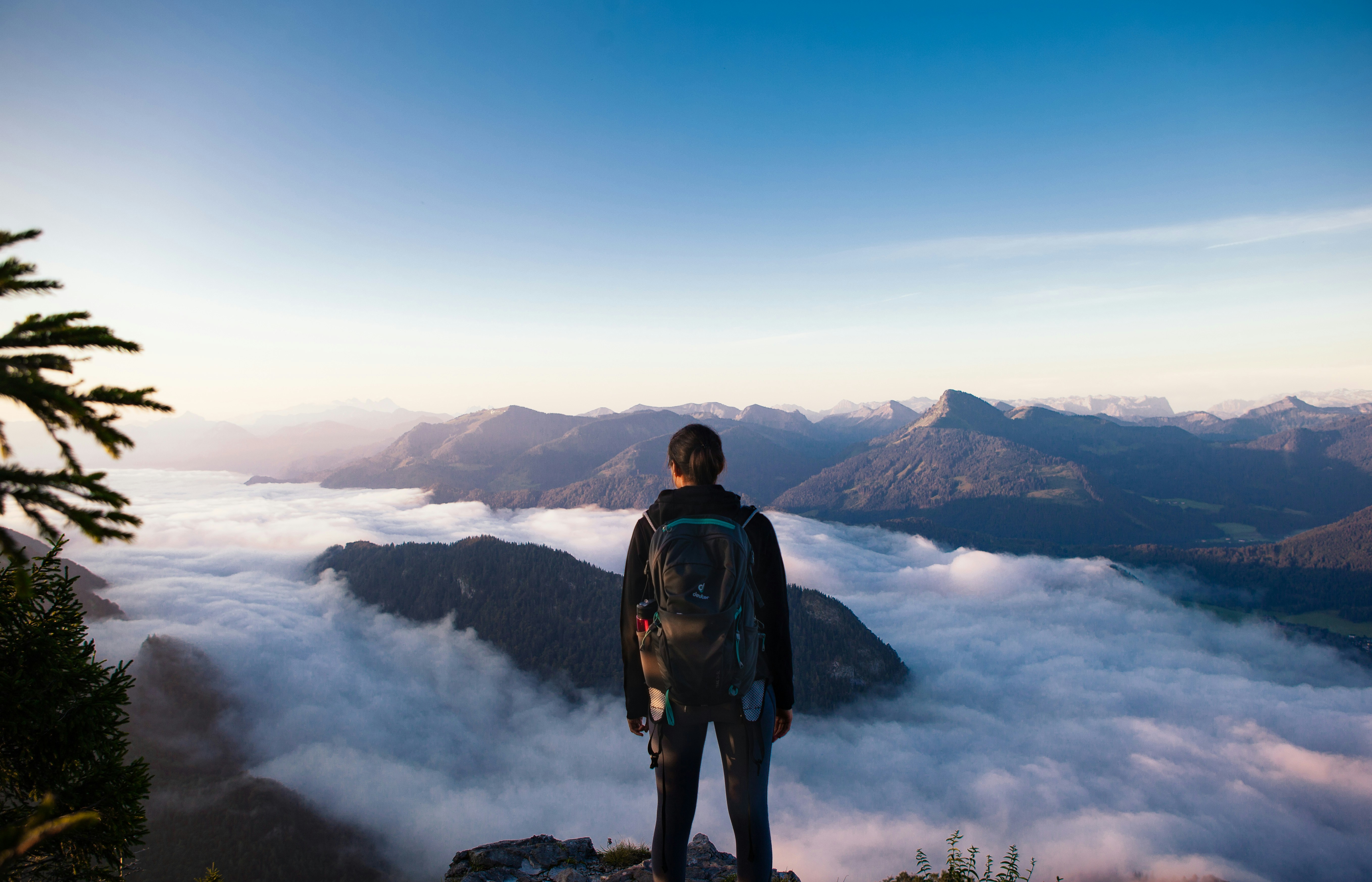 Founder looking out over a mountain ridge above the clouds, representing the RIED research-to-revenue journey